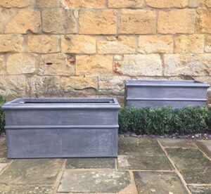 The sleek Magdalen narrow trough lead planter by Oxford Planters.