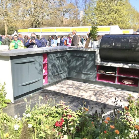 Bespoke Accoya L-shaped outdoor kitchen with integrated shelves and cupboards and a marble top.