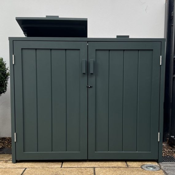 Bespoke double wheelie bin store crafted from Accoya wood and painted deep charcoal grey, featuring vertical panels, front access doors, and an open top lid on a stone patio.