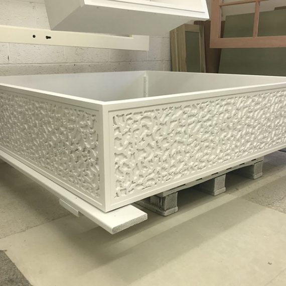 Extra-large bespoke white wooden planter with intricate vermicular rusticated detailing, photographed in the Oxford Planters workshop.