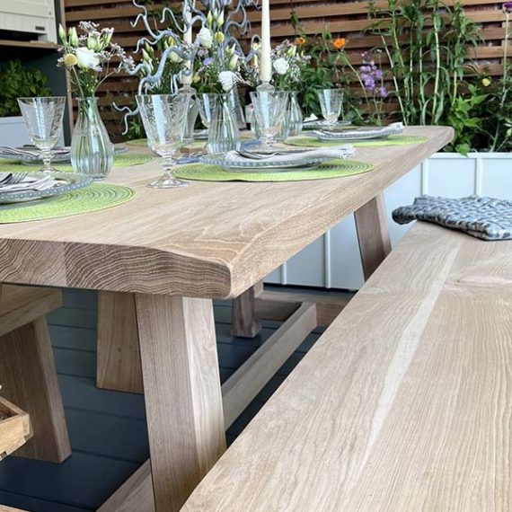 Bespoke solid oak estate garden dining table and matching bench set styled for alfresco entertaining