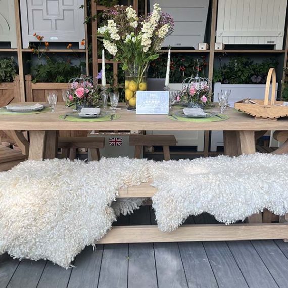 Luxury wooden farmhouse garden dining table set with bench and carver chairs on display