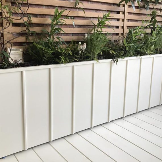 A long thin white trough planter with elegant vertical batten detailing made to order.