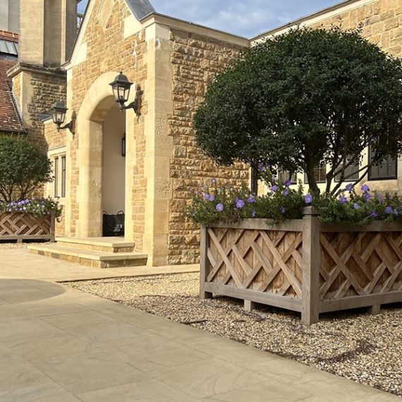 Pair of large bespoke Wolfson solid hardwood planters with Chinese Chippendale lattice detailing, mature topiary trees and flowers at a private Surrey estate.