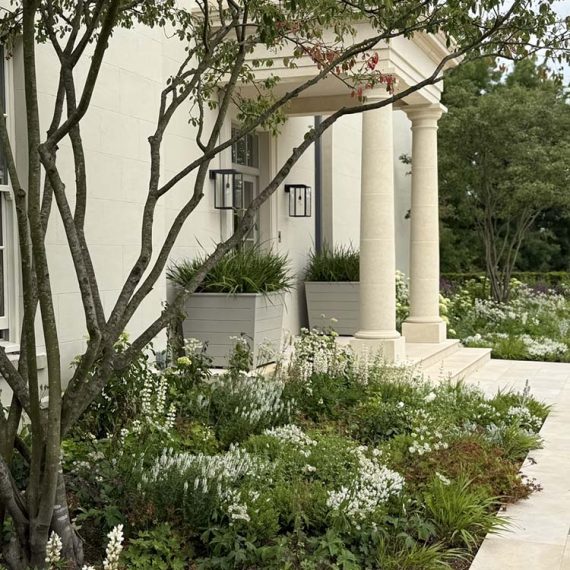 Bespoke luxury horizontally panelled timber cube planters, handmade flawless slate grey painted finish, flanking a classical stone columned portico entrance.