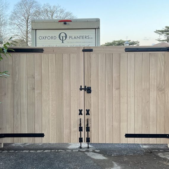 Luxury hardwood timber entrance gates, handcrafted by Oxford Planters from natural hardwood and recessed between traditional brick pillars.