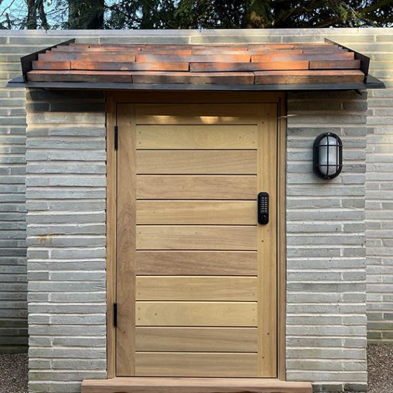 Bespoke luxury horizontal slatted timber garden door handcrafted from premium natural hardwood, built into a contemporary brick outhouse.