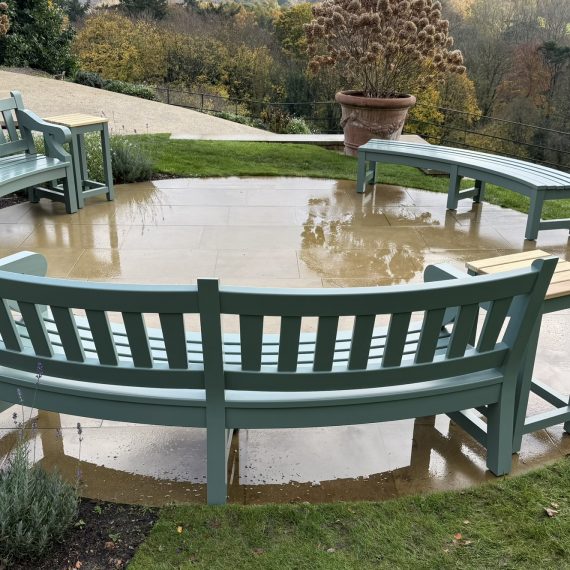 Curved bespoke hardwood Dyffryn benches in Accoya and spray coated in a green hue.