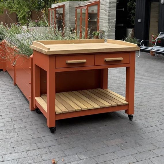 Bespoke luxury potting bench in Accoya painted orange with a solid iroko timber worktop, on movable casters.