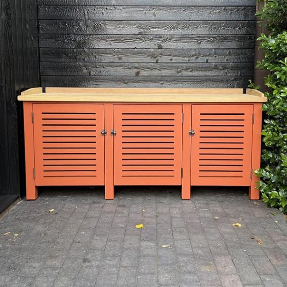 Luxury terracotta orange wooden potting bench and outdoor storage cabinet with a solid natural oak worktop and three louvered doors.