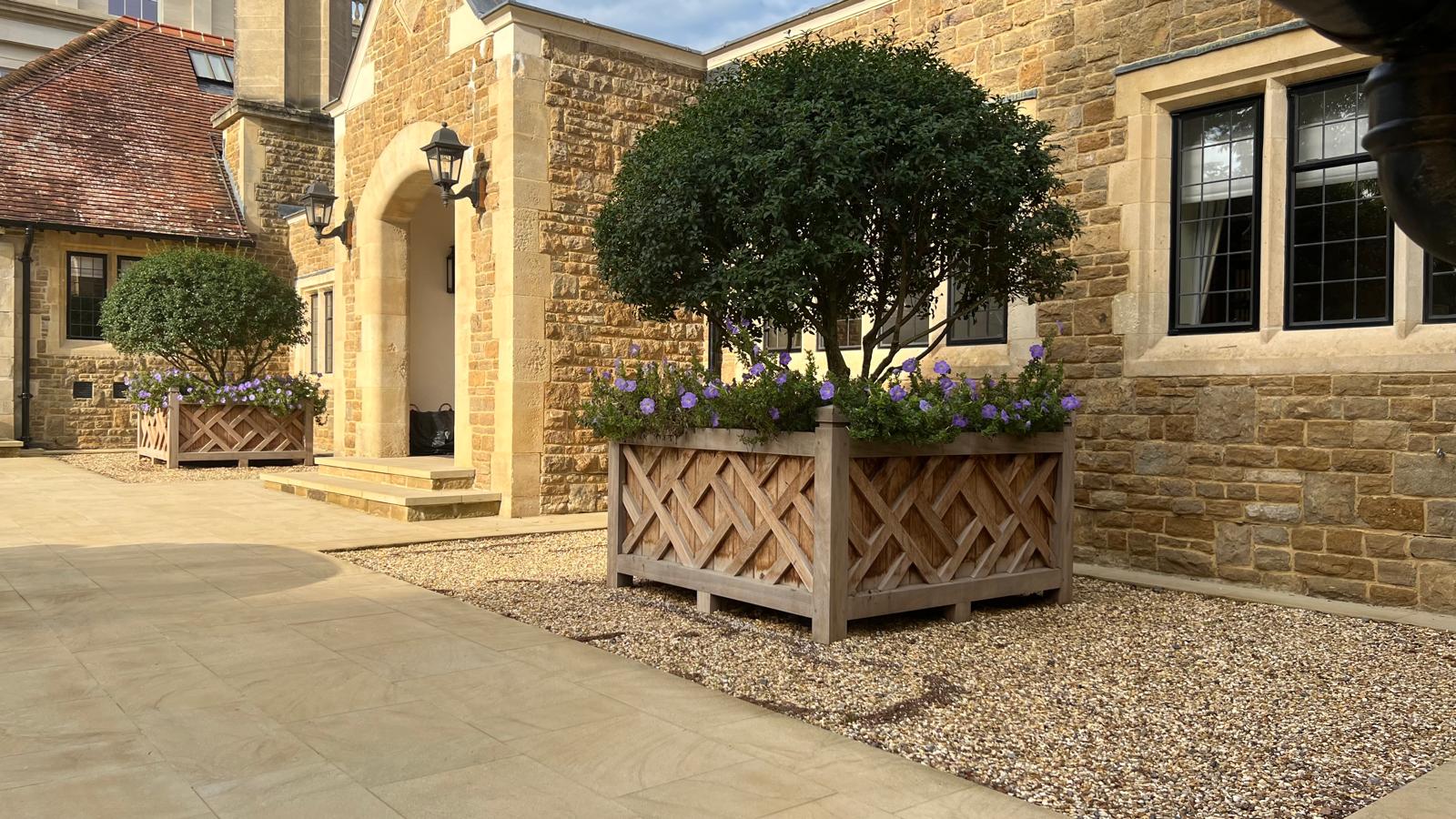 WhatsApp Image 2026-09-17 at 15.43.281 Large architectural wooden planters framing an entrance