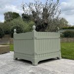 Green Versailles planter in Cotswold property with removable sides for an ancient olive tree