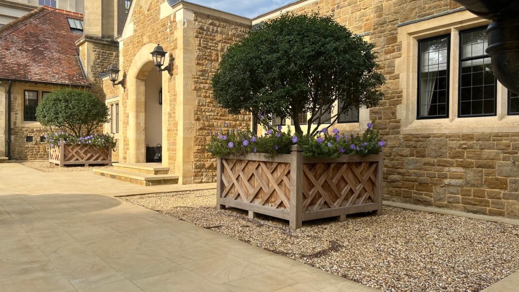Large architectural wooden planters framing an entrance