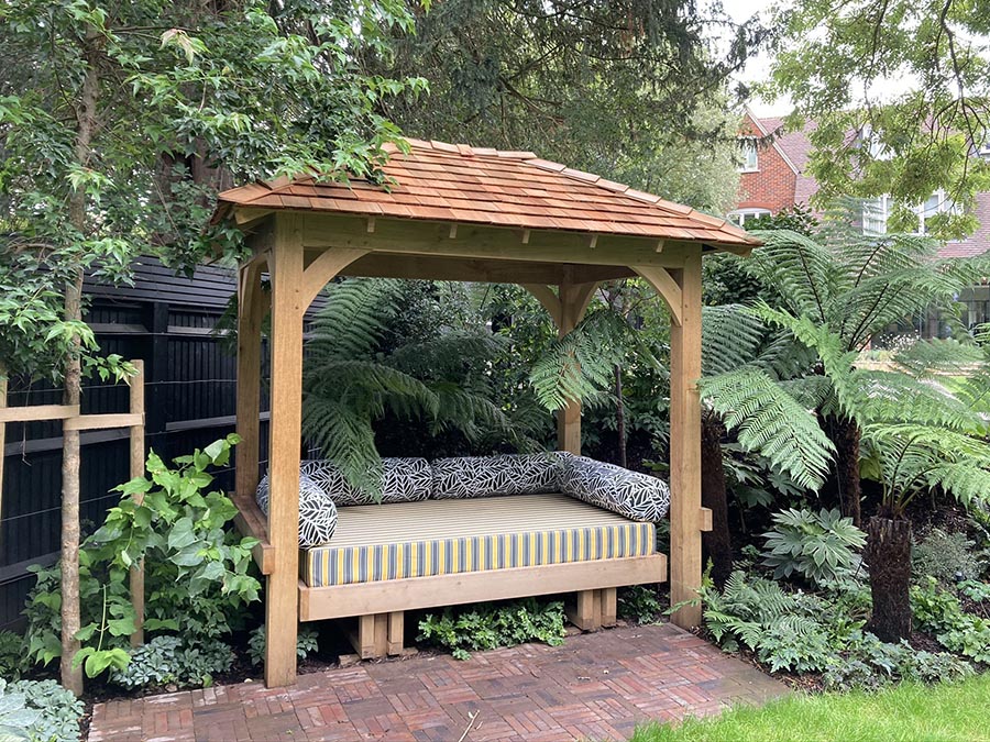 Bespoke wooden rocking daybed in a luxury Wimbledon garden