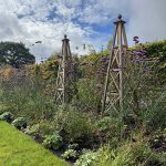 Weathered oak handmade obelisks with ball finials.
