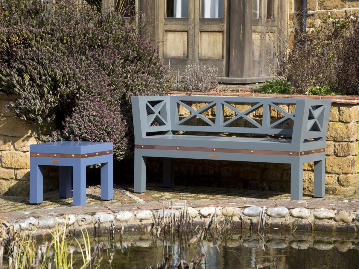 The Designer Stud Detail Bespoke Wooden Bench ArtDeco designer garden bench with cross detailed backrest and copper banding with studs.