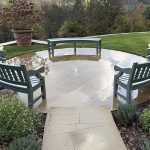 Durable bespoke hardwood garden furniture set featuring three curved wooden benches painted sage green, built for long-lasting exterior seating on a circular patio.
