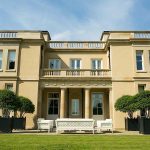 Large black Hertford Versailles-style wooden planters with mature topiary trees on the terrace of a private country manor house