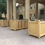 Large bespoke Hertford oak wooden planters arranged outside the entrance of a private country estate.
