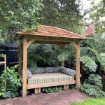 Bespoke upholstered Oak rocking daybed pavilion in a luxury Wimbledon garden