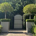 Traditional tapered painted Accoya wooden planters positioned either side of a gate at a Surrey property