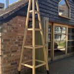 Tall traditional oak garden obelisk with tapered timber frame and trellis detailing, handcrafted for climbing plants.