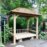 Traditional mortise-and-tenon Oak glider daybed pavilion in a Wimbledon garden